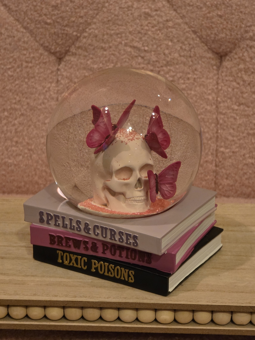 Whimsical Gothic Skull With Pink Butterflies On Base Of Spell Books Snow Globe